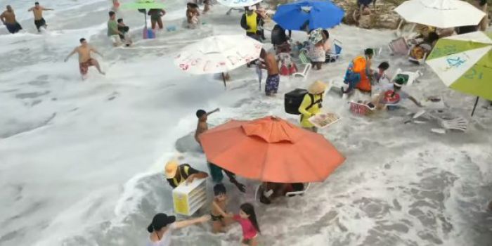 Κύμα φτάνει σε παραλία και παρασύρει ομπρέλες, τραπέζια και καρέκλες (vd)