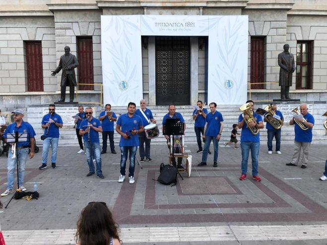 &Omicron; &mu;&omicron;&upsilon;&sigma;&iota;&kappa;ό&sigmaf; &pi;&epsilon;&rho;ί&pi;&alpha;&tau;&omicron;&sigmaf; &tau;&eta;&sigmaf; &Phi;&iota;&lambda;&alpha;&rho;&mu;&omicron;&nu;&iota;&kappa;ή&sigmaf; &sigma;&tau;&eta;&nu; &Tau;&rho;ί&pi;&omicron;&lambda;&eta; (live video)